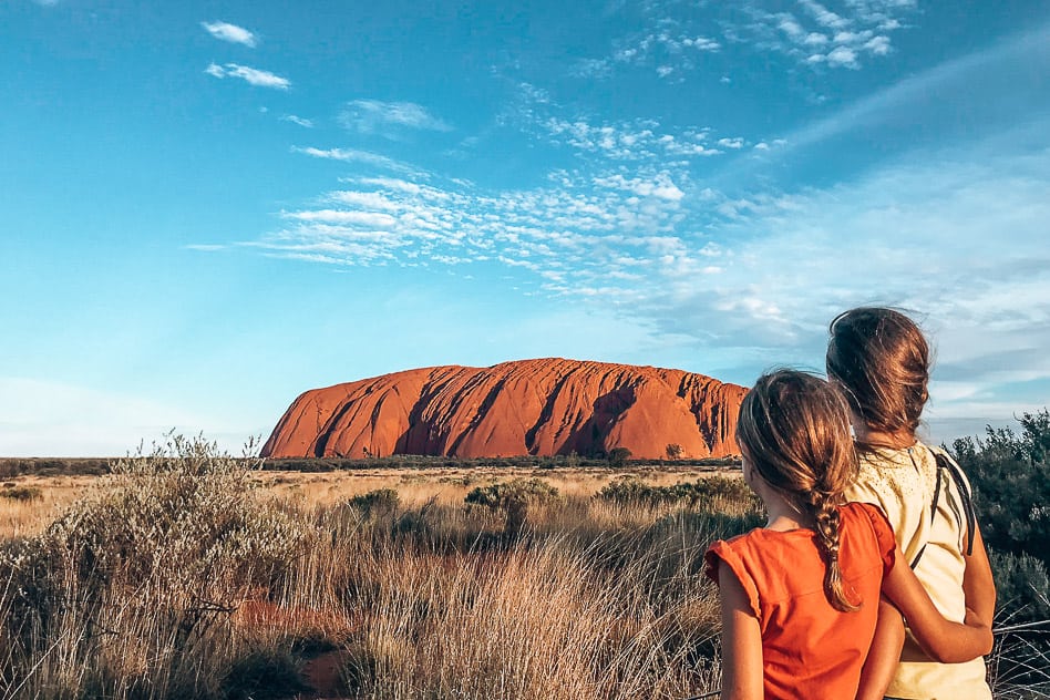 Op weg van Darwin naar Uluru. O nee, de auto is kapot... Sunset by Uluru or Ayers Rock with kids in the Outback of Australia
