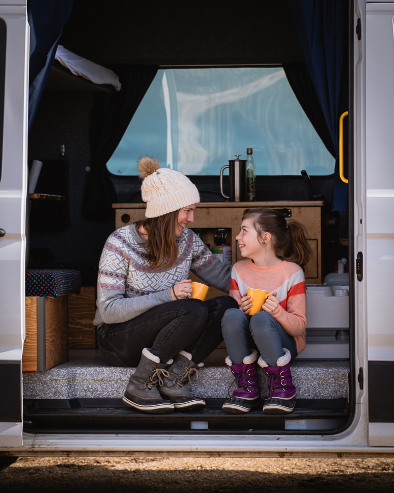 What to wear in Iceland in winter: the best clothing for Iceland from October to April mom and daughter in a camper in Iceland, dressed with Icelandic sweater and warm winterboots