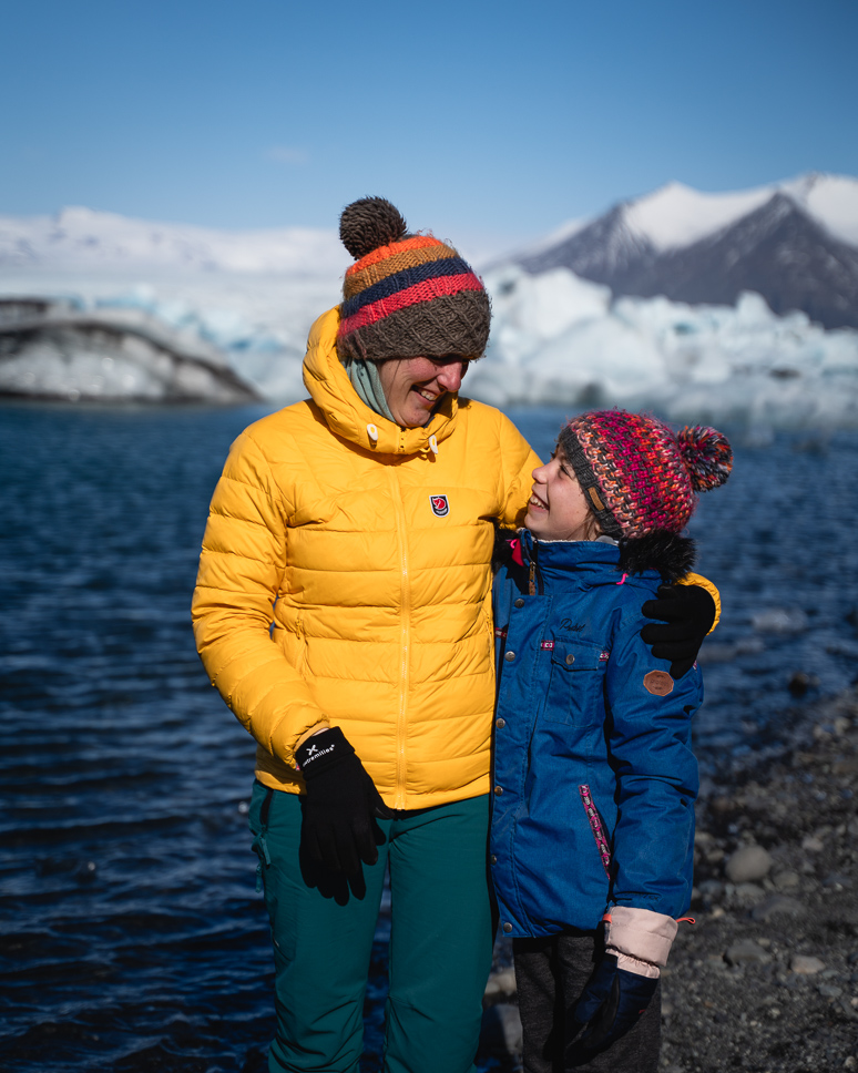 What to wear in Iceland in winter: the best clothing for Iceland from October to April mother and daughter in winter in iceland, smiling with hat, gloves and a buff against the cold