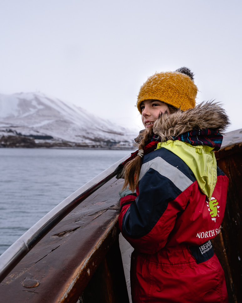 Whale Watching in Iceland: Where and When + Our Top Tips girl spotting whales in the north of iceland with North Sailing