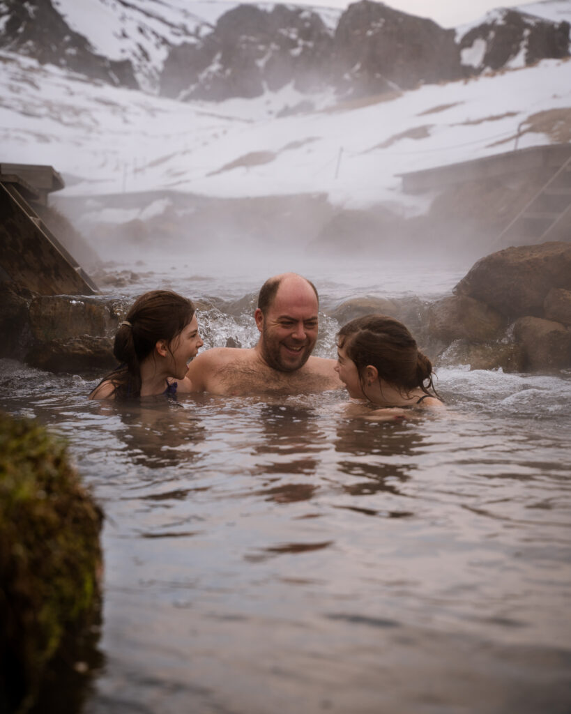 15 best and most impressive things to do in Iceland dad with two kids bathing in reykjaladur in iceland