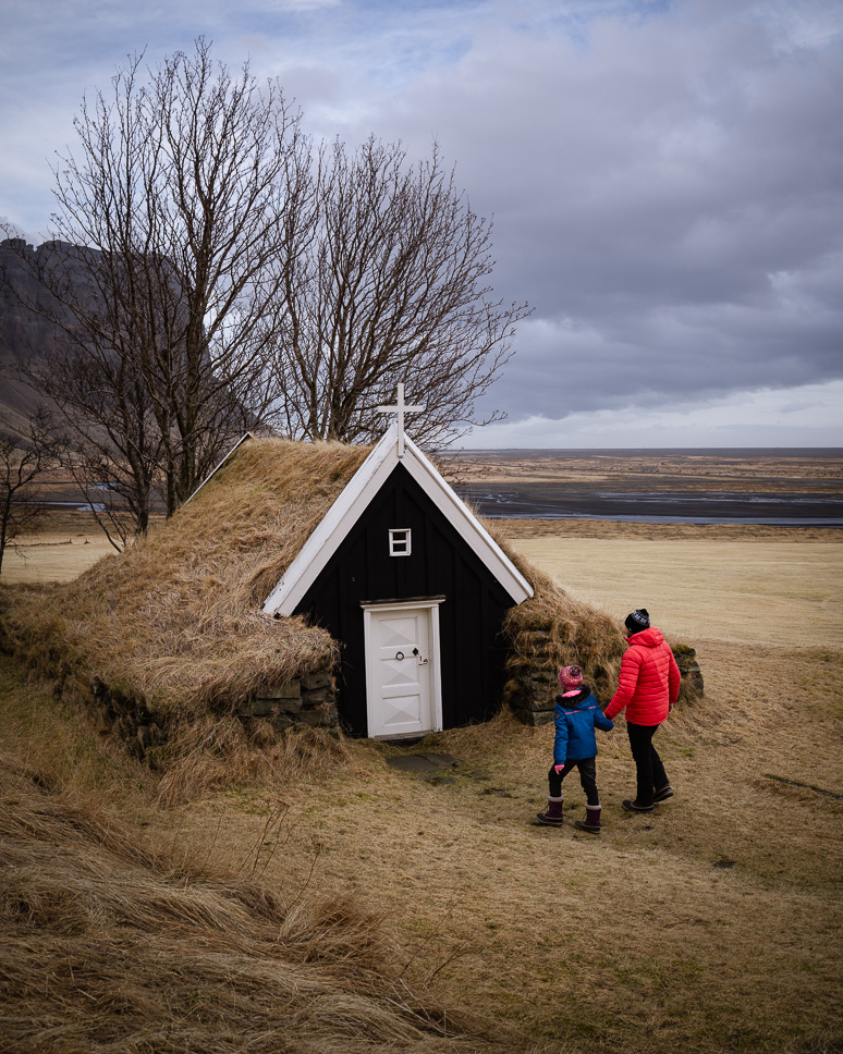 Ultieme rondreis IJsland: 10 dagen of 2 weken roadtrip Vader en kind wandelen naar een turf kerkje in Zuid Ijsland