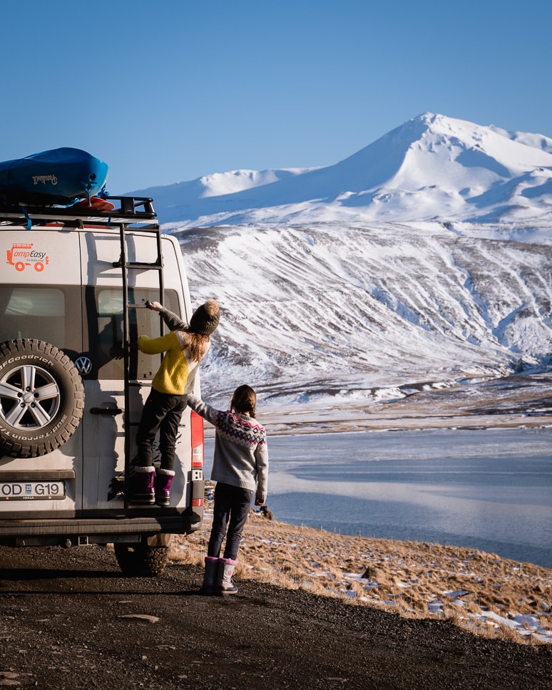 Two kids who watch a mountain with snow in Iceland