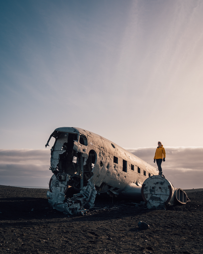 20+ Best things to do in Iceland: Our Ultimate Iceland Bucket List Woman stands on Sólheimasandur plane wreck at sunset in Iceland