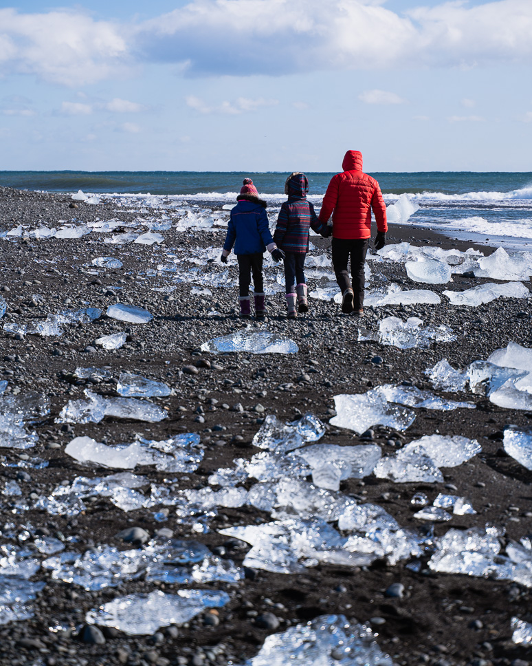 20+ Best things to do in Iceland: Our Ultimate Iceland Bucket List Family walks on Diamond Beach in Iceland along the black sand beach surrounded by blocks of ice