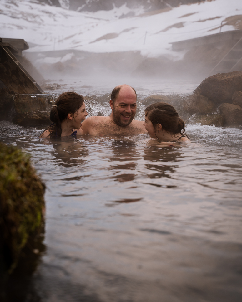 20+ Best things to do in Iceland: Our Ultimate Iceland Bucket List Family in natural hot water river Reykjadalur in Iceland surrounded by snow