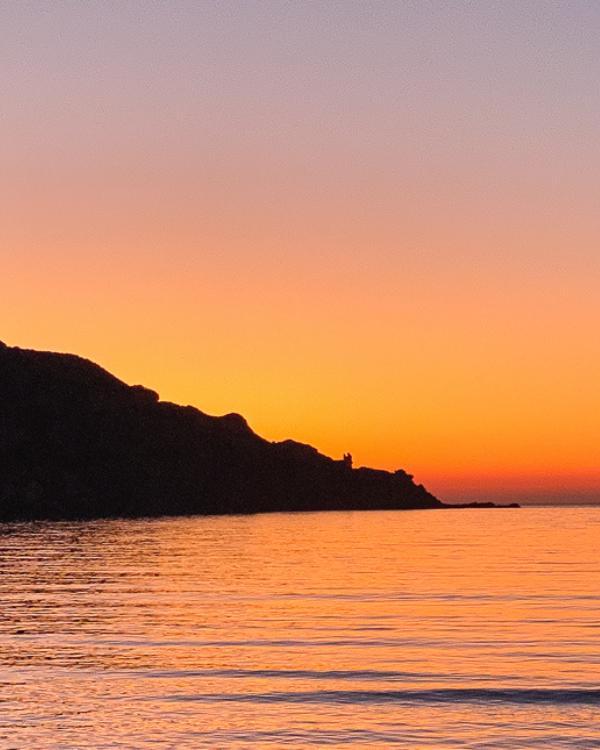 What to do on Syros: Our favourite island in the Cyclades zonsondergang aan Kini Beach in Syros