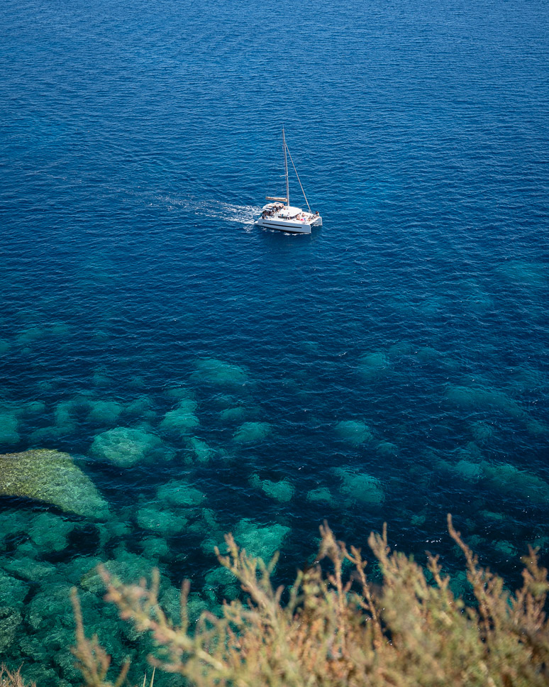 View of a catamaran and azure water from the citadel in Bonifacio.